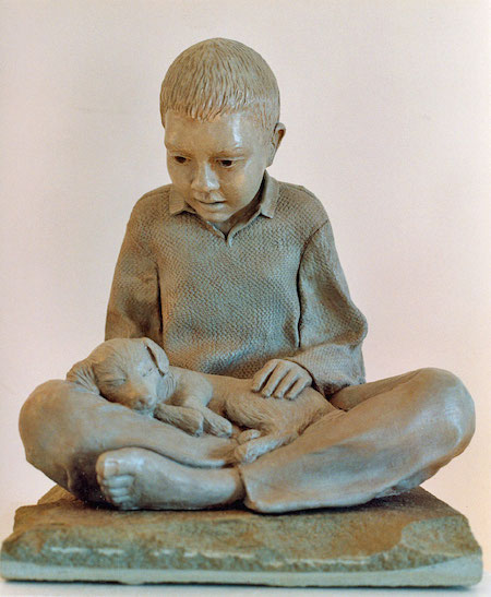 Photo of a sculpture of a young boy with a sleeping puppy in his lap