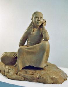 Photo of a sculpture of young girl listening to a sea shell