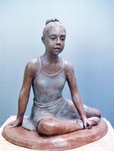 Photo of a sculpture of a young dancer sitting on the floor